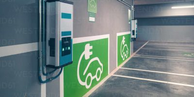 Electric car charger signs and charging points for electric vehicles on gray wall at electric car charging station